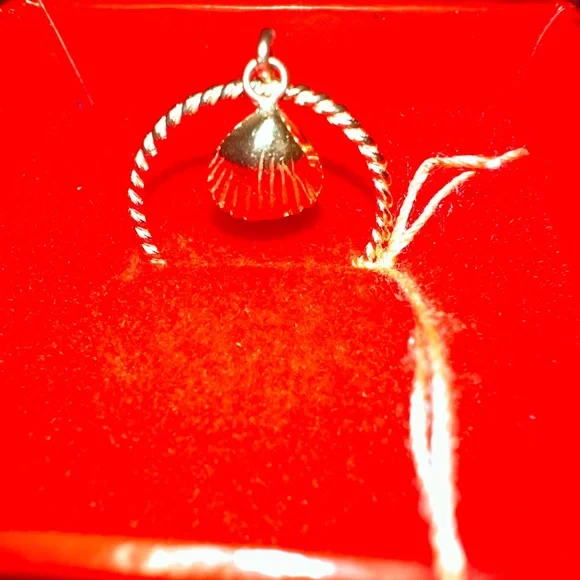 14 karat yellow gold cable ring with a beautiful shell hanging
